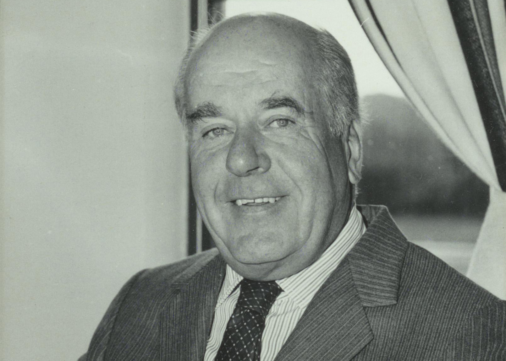 A greyscale photograph of Lord Butterworth in his office