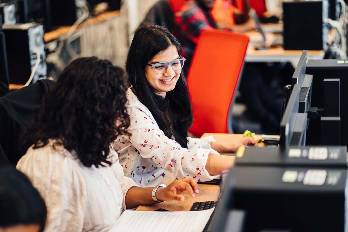 BSc Cyber Security students in computer lab working together at desks