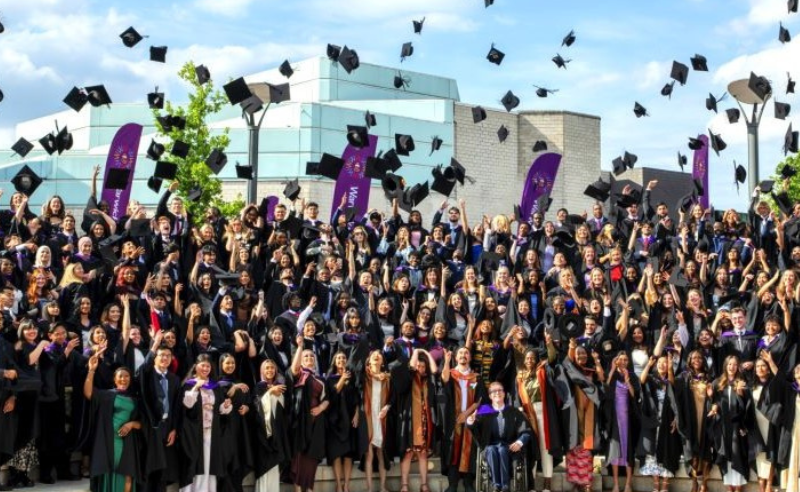 students graduating throwing their caps in the air
