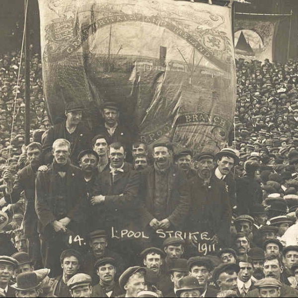 Balck and white photograph of a group of men standing in the middle of a large crowd at then National Transport Strike holding a "Liverpool Branch" banner