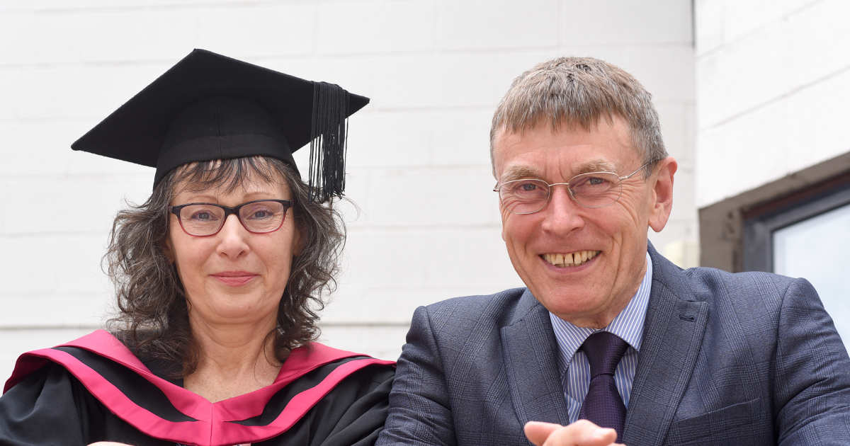 a CLL graduate in graduation gown next to her husband
