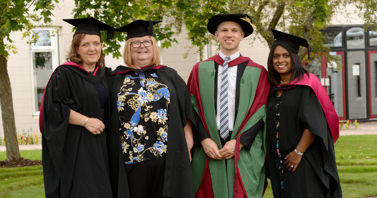 Four graduates wearing graduation robes