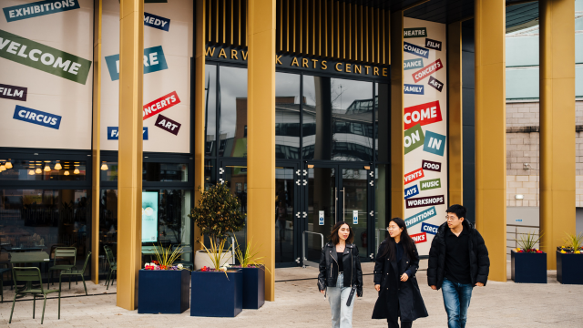 This image shows a group of students socialising outside of the Warwick Arts Centre on Campus.