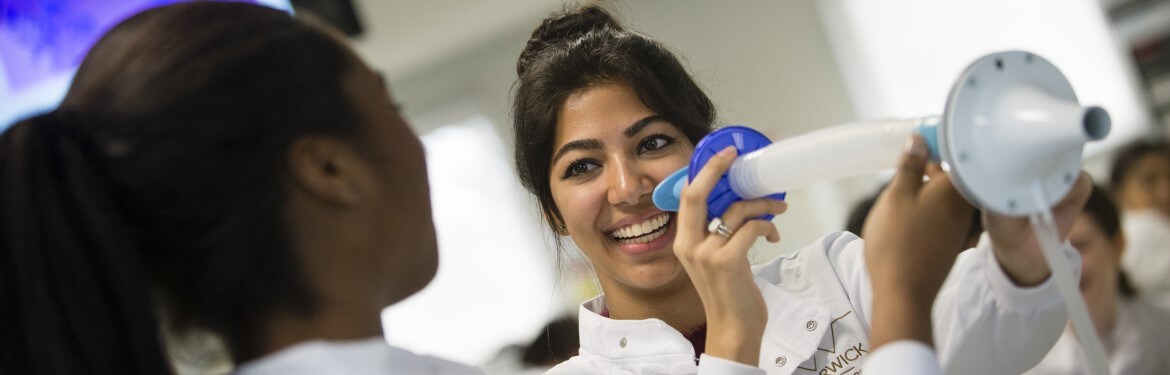 Biomedical students holding a breathing apparatus.